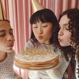 Friends blowing out birthday candles